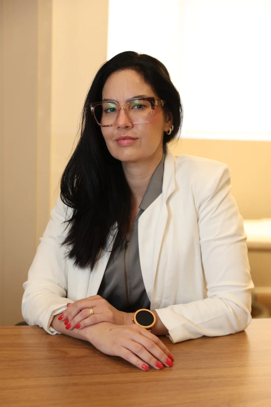 Retrato profissional da Dra. Sandra da Silva Pernisa, sentada à mesa