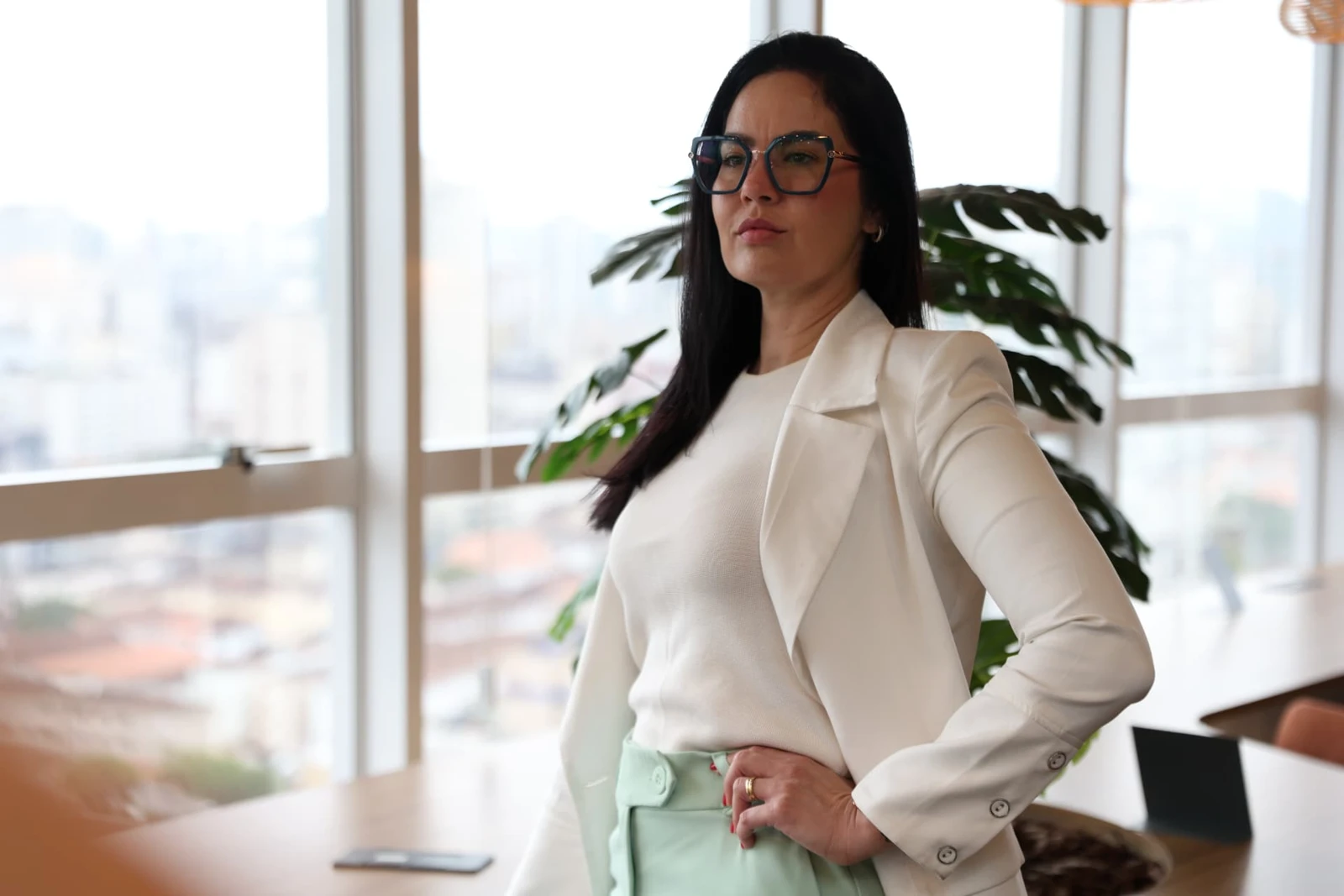 Dra. Sandra da Silva Pernisa junto à janela, em um ambiente iluminado